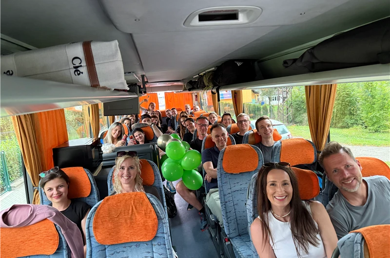 Tým Libristo sedí v autobuse a usmívá se do fotoaparátu